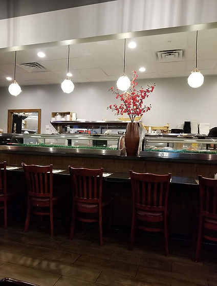 寿司店吧台陈设，红木椅子，酒杯悬挂在天花板上，花瓶摆放中央。