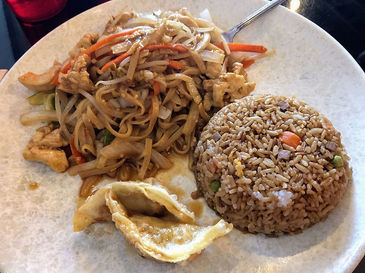 盘子里的炒面、米饭和饺子,美味的亚洲美食。Home
