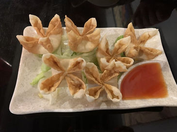 盘子里的炸蟹角,旁边放着红色的蘸酱,美味的中式菜肴。